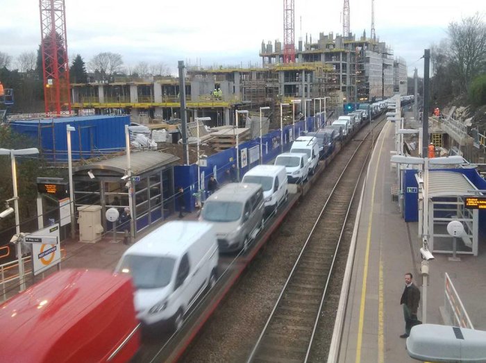 A train of Ford vehicles rolling through West Hampstead Overground station via Mark Amies 